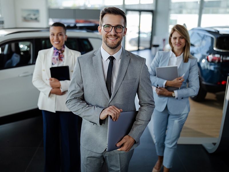 2 ladies and a gentleman with their tablests - Vann York Buick GMC staff welcoming customers at the High Point, NC dealership showroom