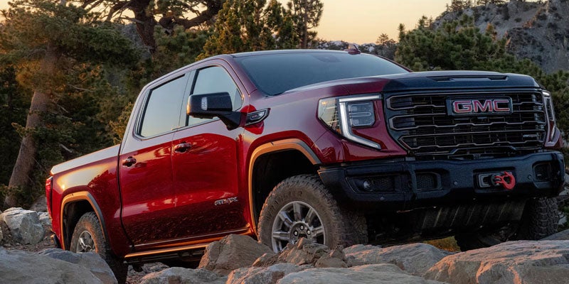2026 GMC Sierra 1500 AT4X driving on a rocky off-road trail